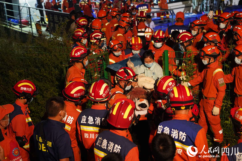 9月5日晚，雅安消防支队在新民乡码头，消防救援人员与多方救援力量一起运送伤员。郑竺青摄