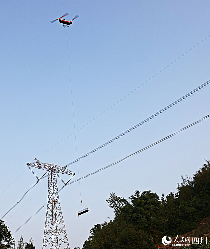 無人直升機正在吊運塔材。王志奇攝
