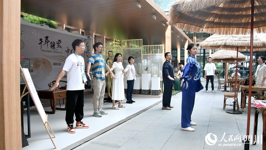展示區工作人員正在帶領參觀者體驗八段錦。人民網記者 王洪江攝