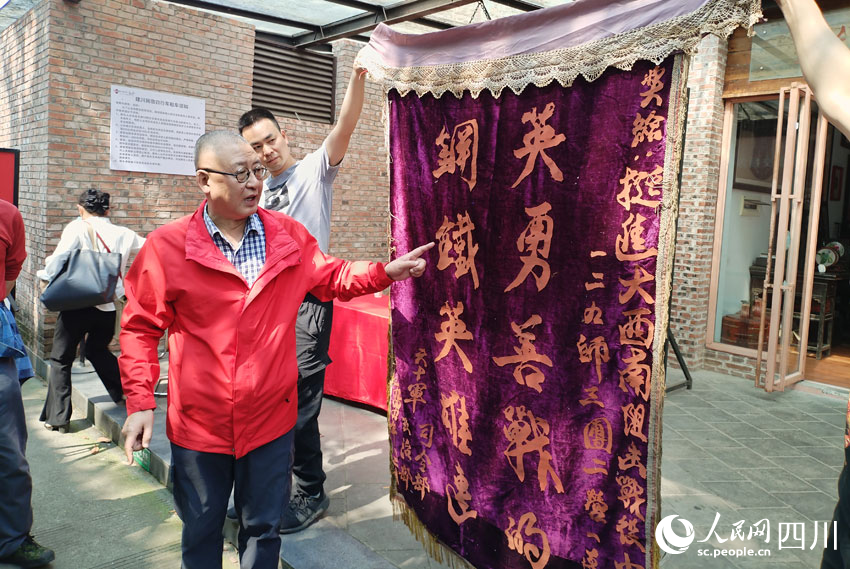 樊建川展示解放军获得的锦旗。人民网记者 刘海天摄
